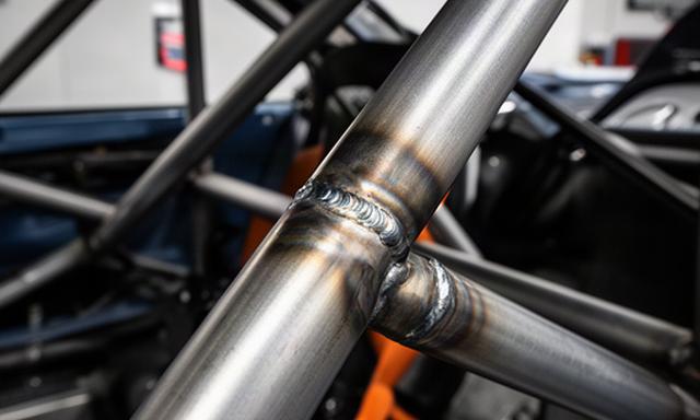 Close-up van een gelaste rolkooi in een raceauto met zichtbare buizen en lasnaden